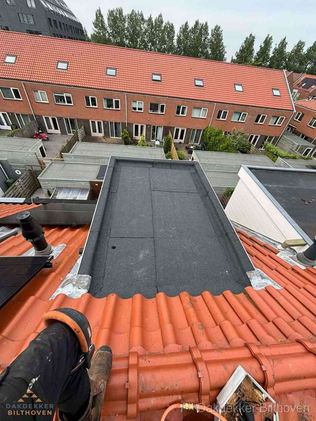 Bitumen dak reparatie op plat dak tussen dakpannen in Bilthoven
