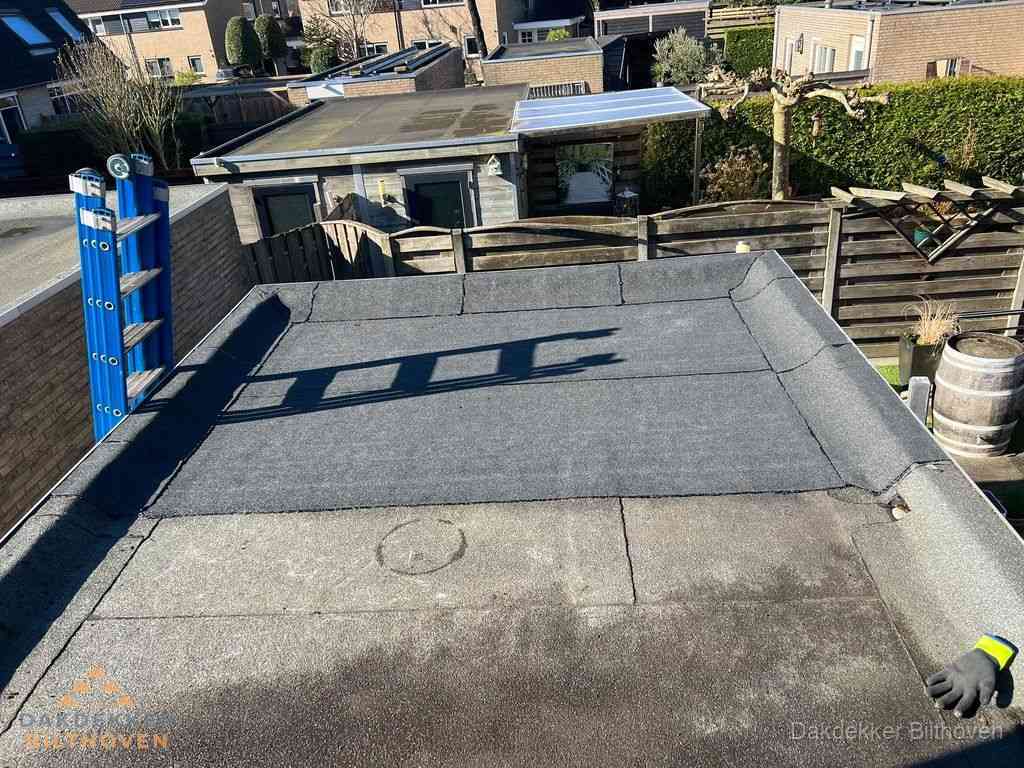 Dakdekker legt onderlaag op plat dak met houten constructie in Bilthoven