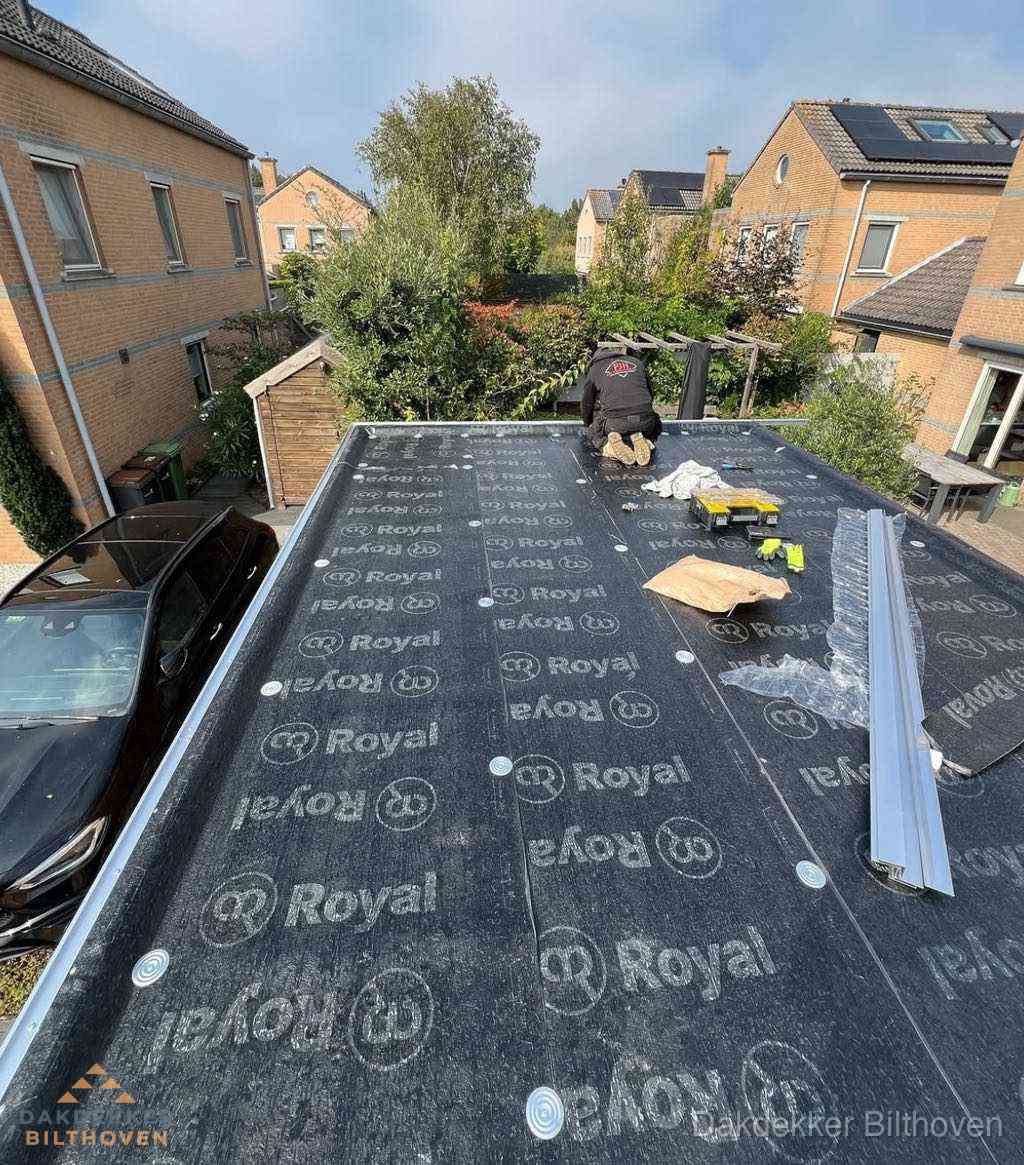 Dakdekker aan het werk op plat dak renovatie in Bilthoven