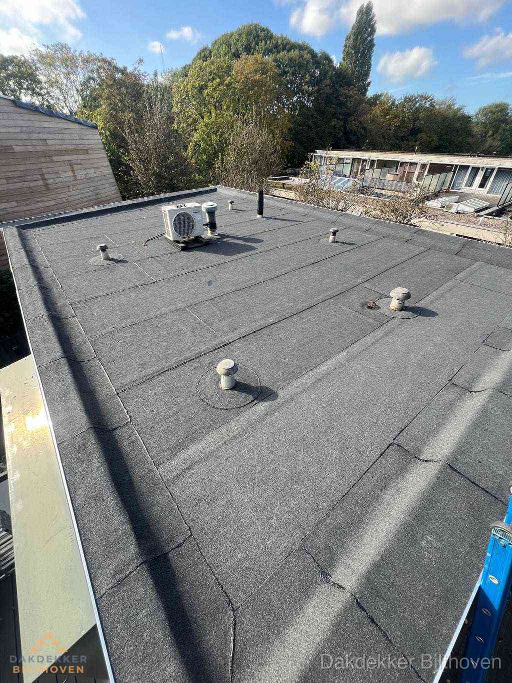 Plat dak met bitumen en brandgereedschap van dakdekkersbedrijf in Bilthoven