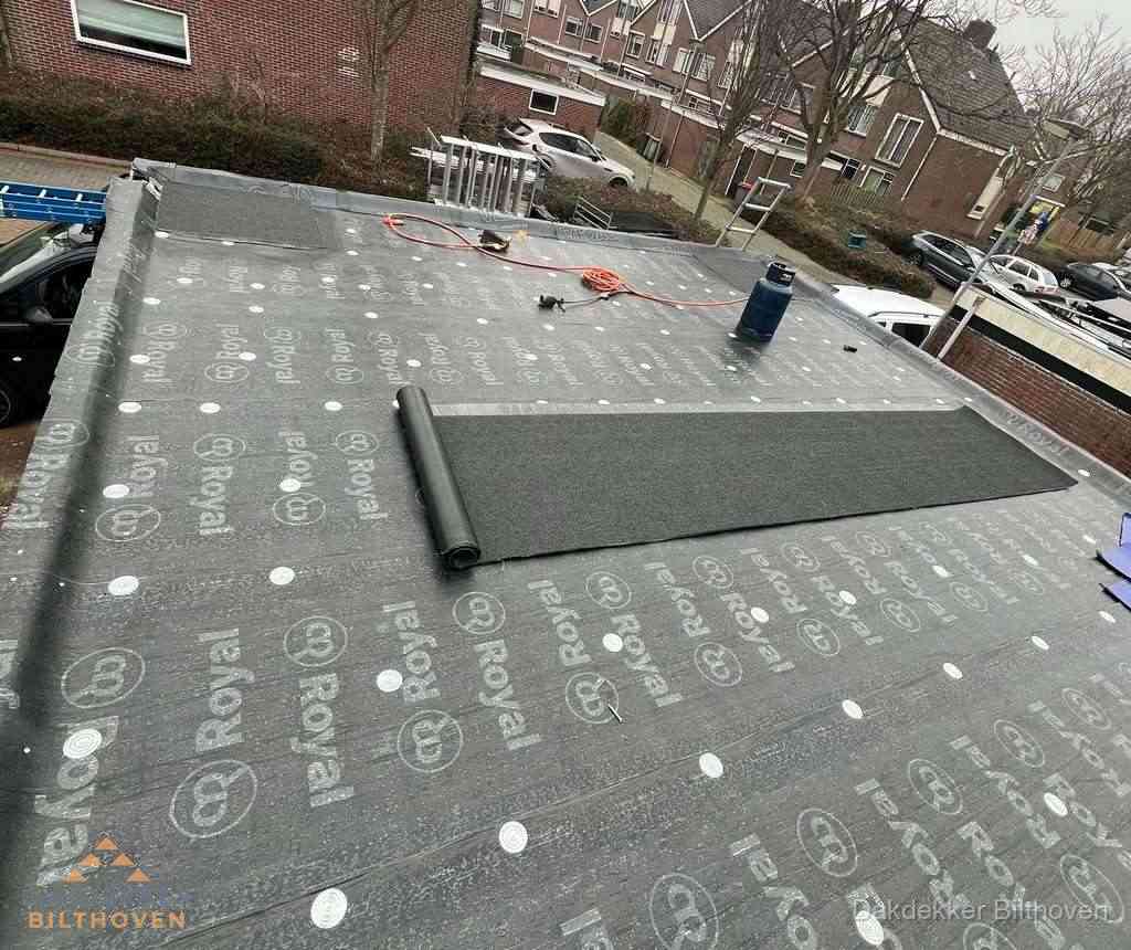 Dakdekker aan het werk met gasbrander op plat bitumen dak in Bilthoven